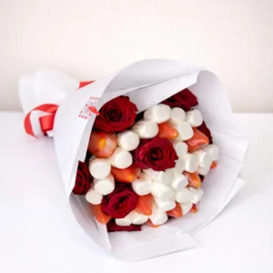 Hand-held edible bouquet featuring fresh red roses, juicy strawberries, and white marshmallows wrapped in white paper with a red ribbon ready to get delivered for free to abovyan and yerevan