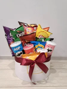 Premium white gift box with maroon ribbon and a wide assortment of chips from various brands` Pringles, Doritos, Lay's