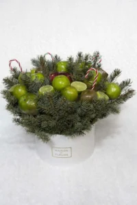 Sophisticated Armenian gifts for her: tangerine bouquet in a white hat box with natural evergreen boughs and festive candy canes.