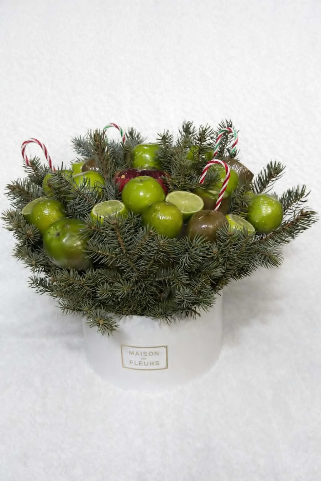 Sophisticated Armenian gifts for her: tangerine bouquet in a white hat box with natural evergreen boughs and festive candy canes.