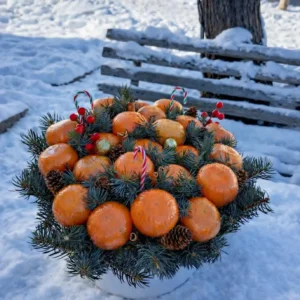 Luxury Christmas tangerine gift box: edible bouquet of fresh tangerines, pine branches, cones, red berries, candy canes, and ornaments