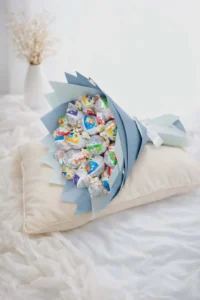 A 25cm artisanal chocolate bouquet composed of Kinder surprise eggs and white baby's breath wrapped in layered pastel blue florist paper.Ready to get delivered to Abovyan ,yerevan and kotyk same day delivery 