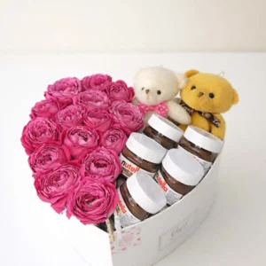 Luxury white heart-shaped gift box filled with fresh magenta peony roses, Nutella chocolate jars, and two teddy bears